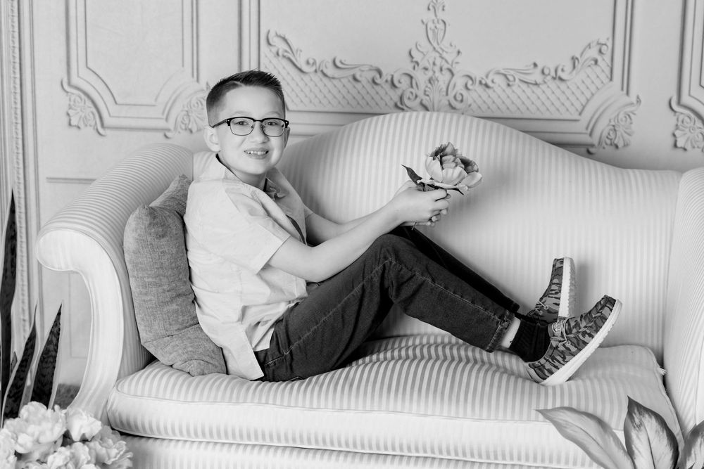 Black and white collage shows four connected portraits of a person lounging on white furniture.
