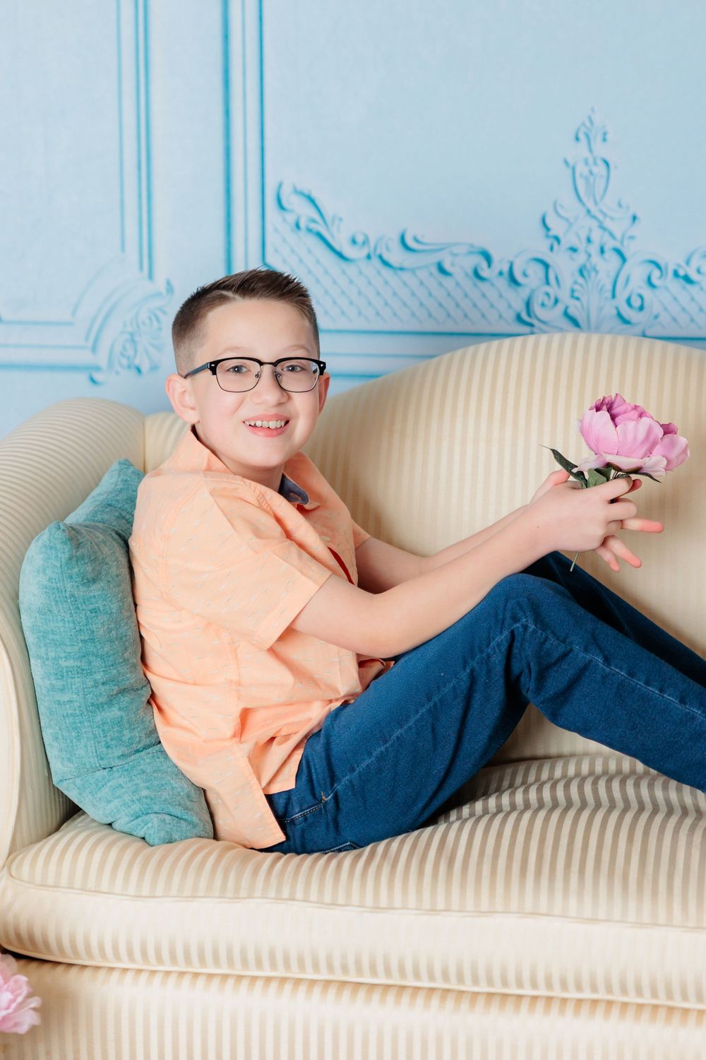 A person lounges comfortably on a cream sofa with decorative blue wall molding in the background.
