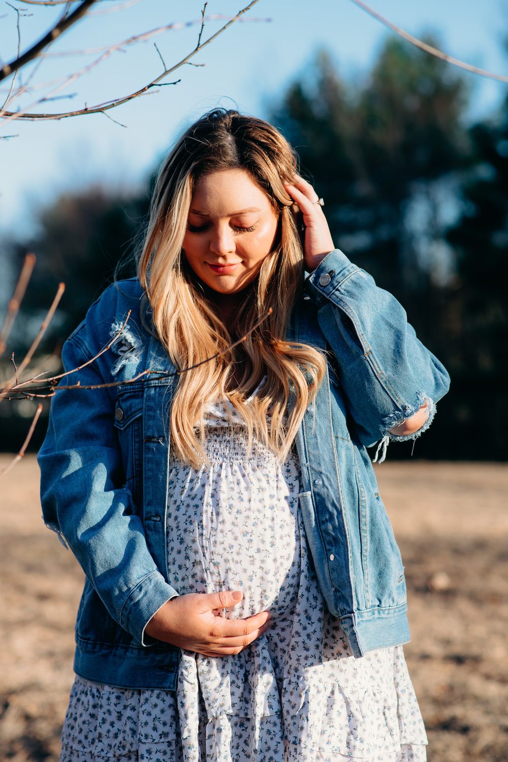 pregnant mama in blue jean jacket posing for outdoor maternity photoshoot
