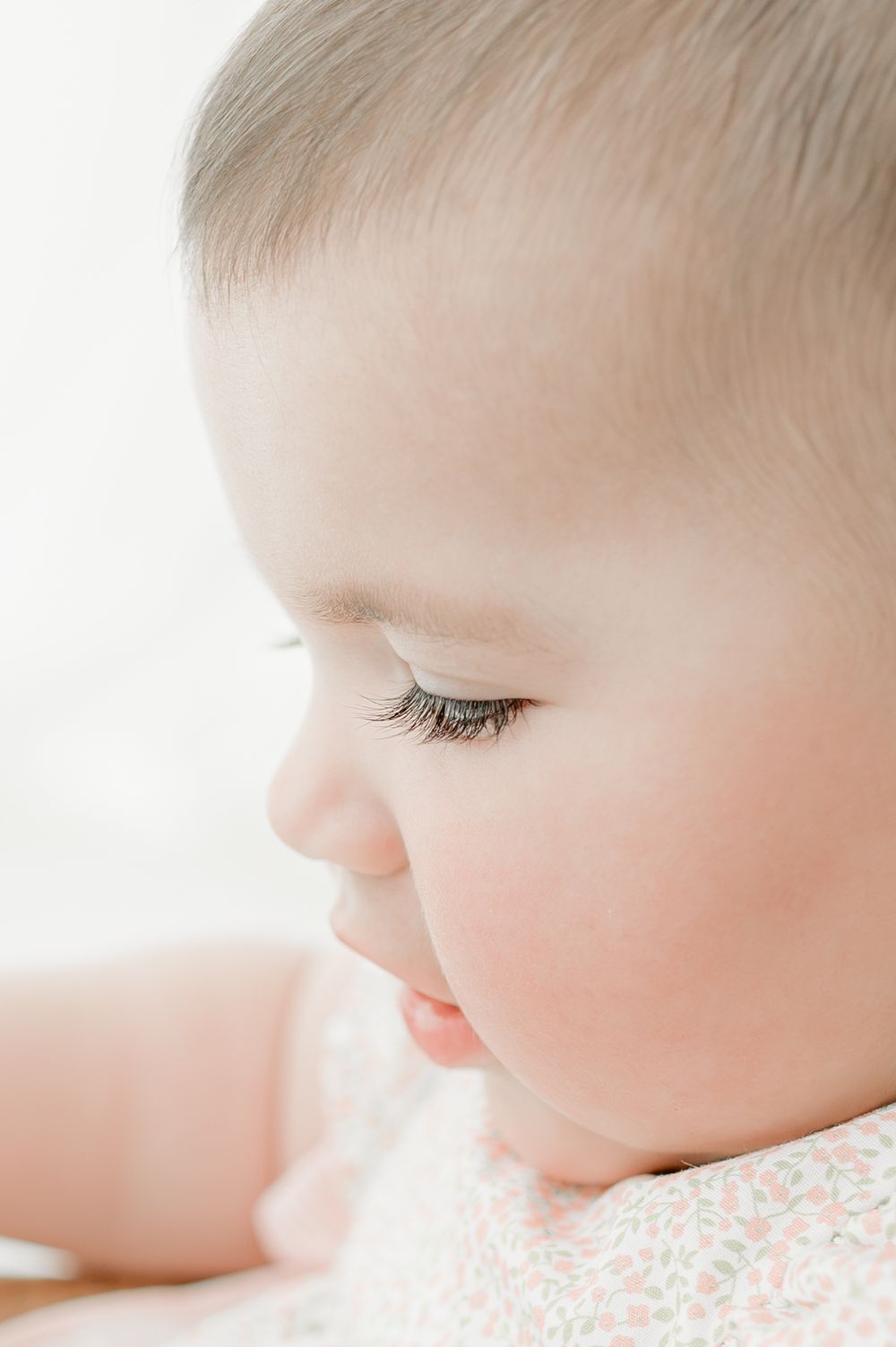 A series of soft, dreamy close-up photos showing a baby's face in profile against a white background.