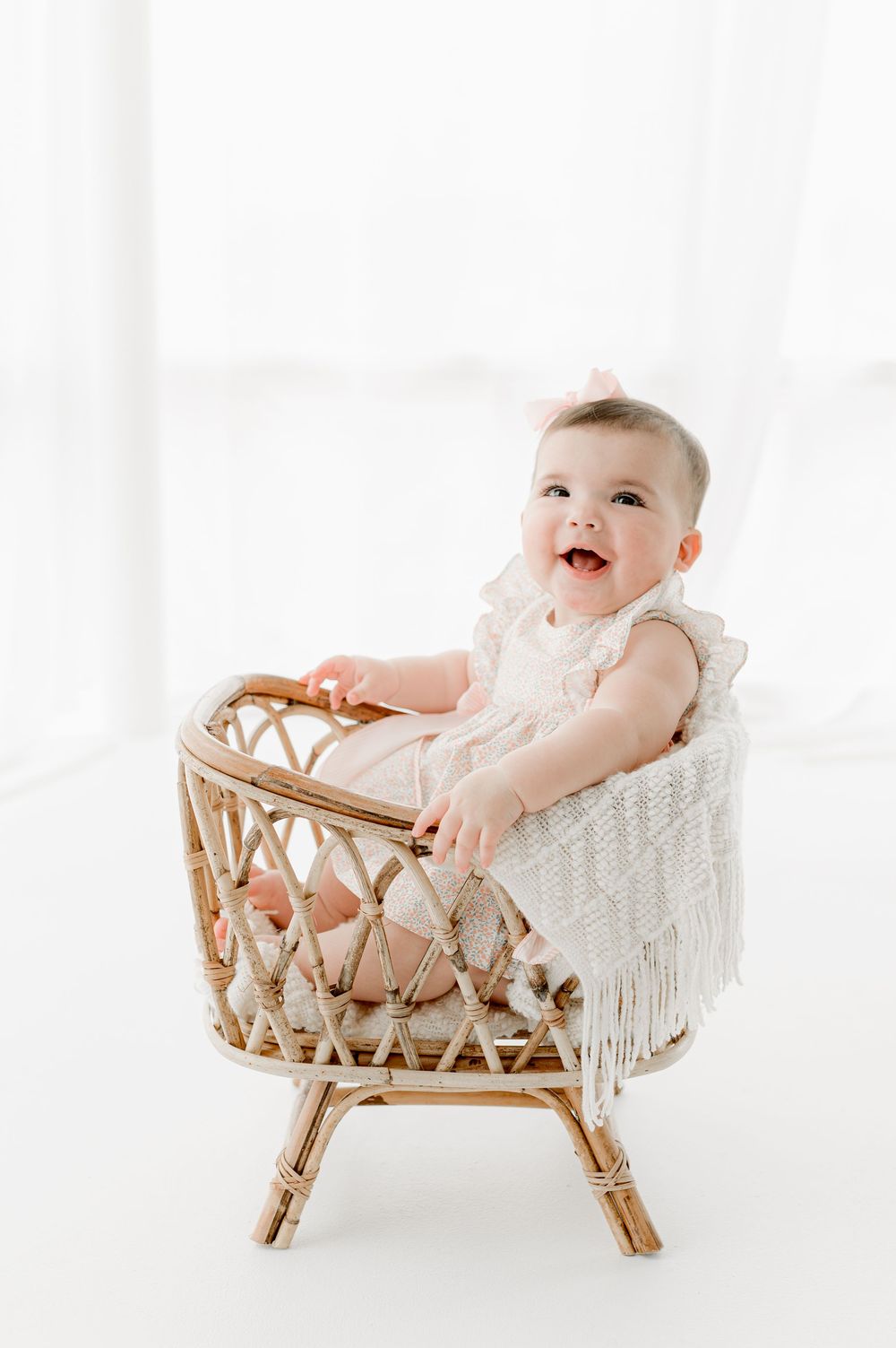 Three photos of a baby lying in a white cushioned rattan bassinet against a bright white background.