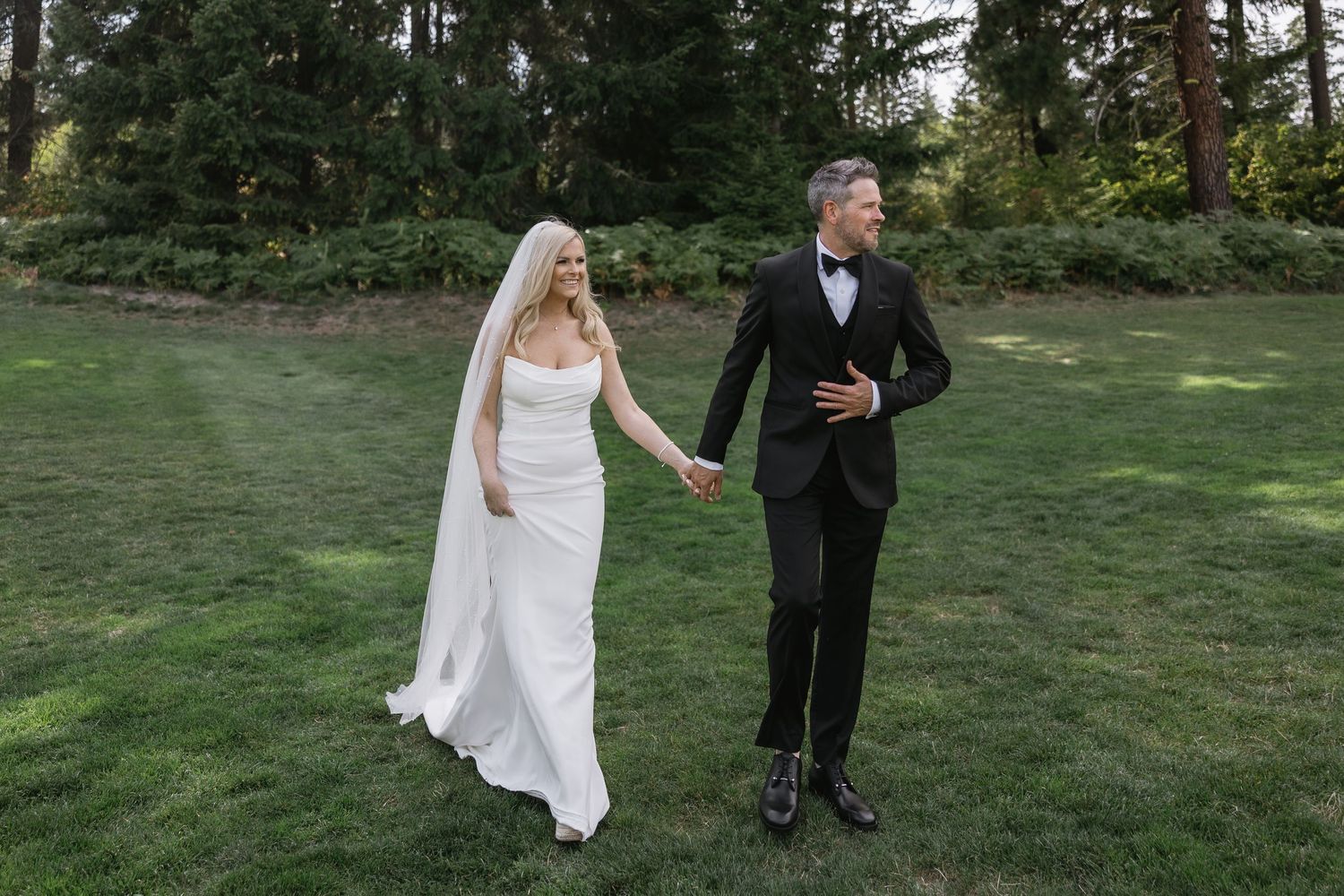 Bride and groom share first dance under twinkling fairy lights at elegant wedding reception.