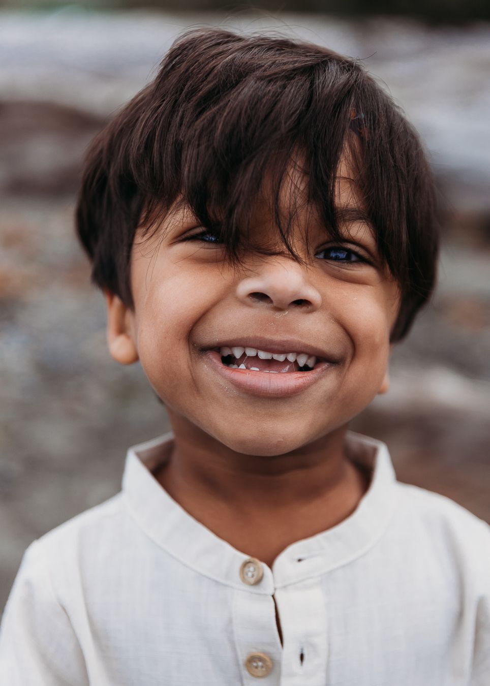 A child in a white shirt shows different playful facial expressions in a series of close-up portrait shots.
