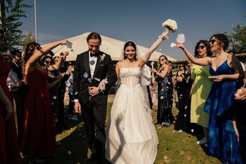 Wedding guests celebrate with sparklers during an outdoor evening reception.