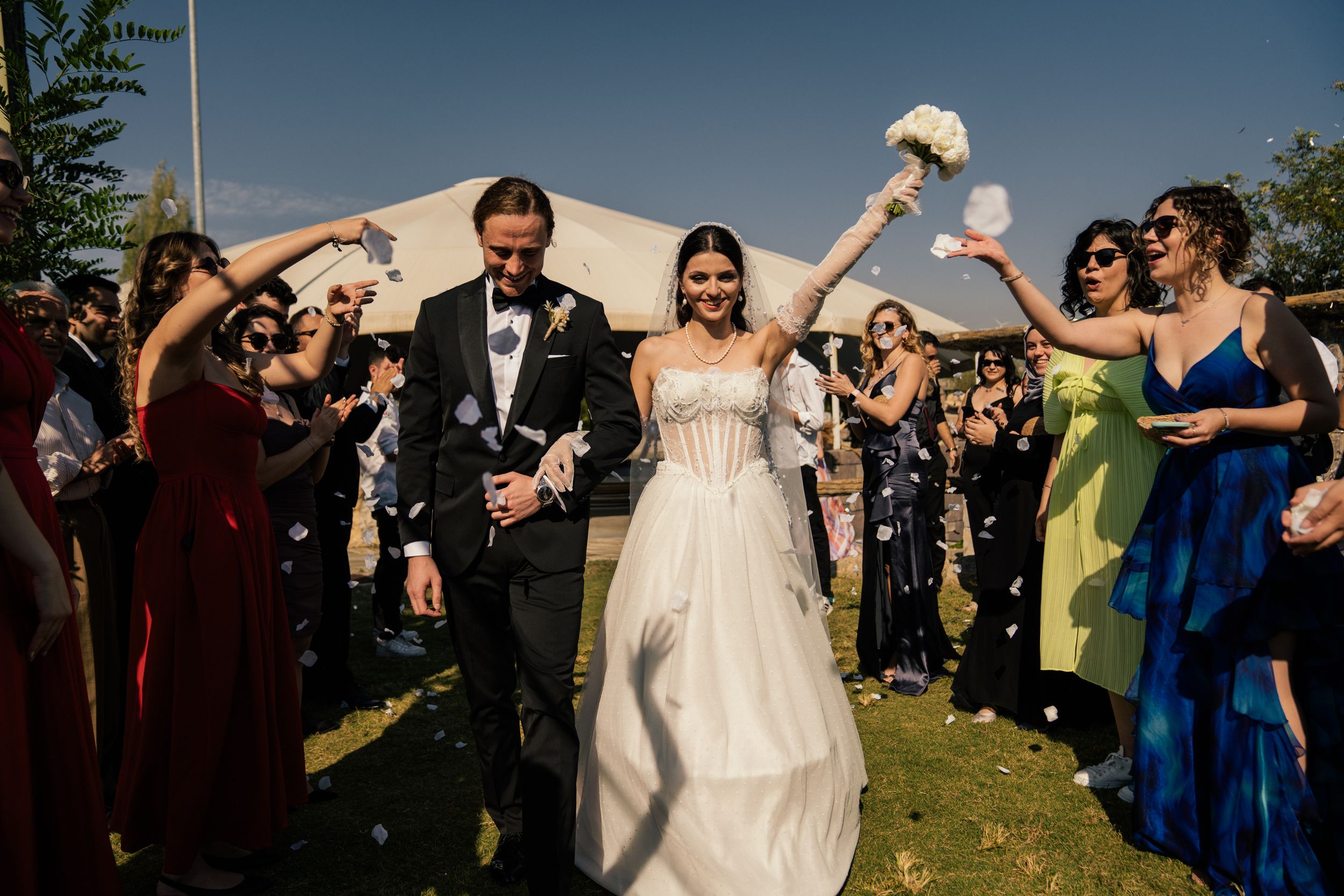Wedding guests celebrate with sparklers during an outdoor evening reception.