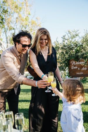 Wedding guests enjoy drinks and conversation at outdoor reception.