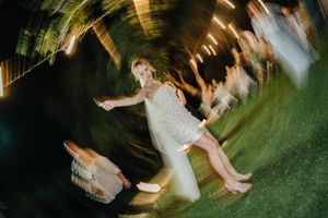 Wedding couple dances together in a romantic outdoor garden setting with swirling motion blur effect.