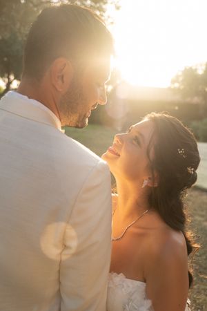 Romantic sunset wedding portrait silhouetted against warm golden light.