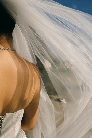 Flowing white wedding veil billowing in the breeze creates an ethereal and romantic effect.