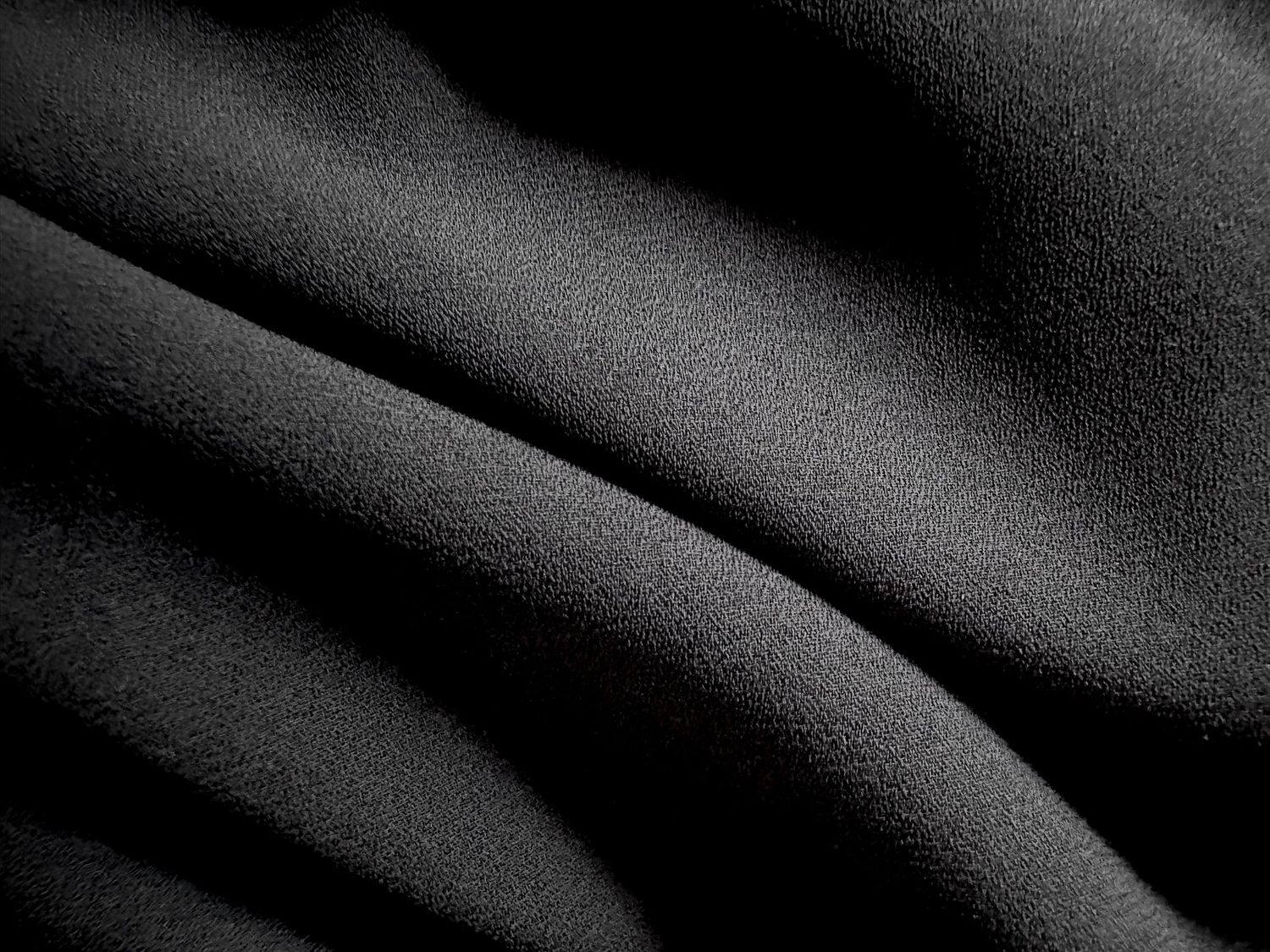 A sample of a black chiffon fabric that can be worn wrapped over the body for  pregnancy portraits.
