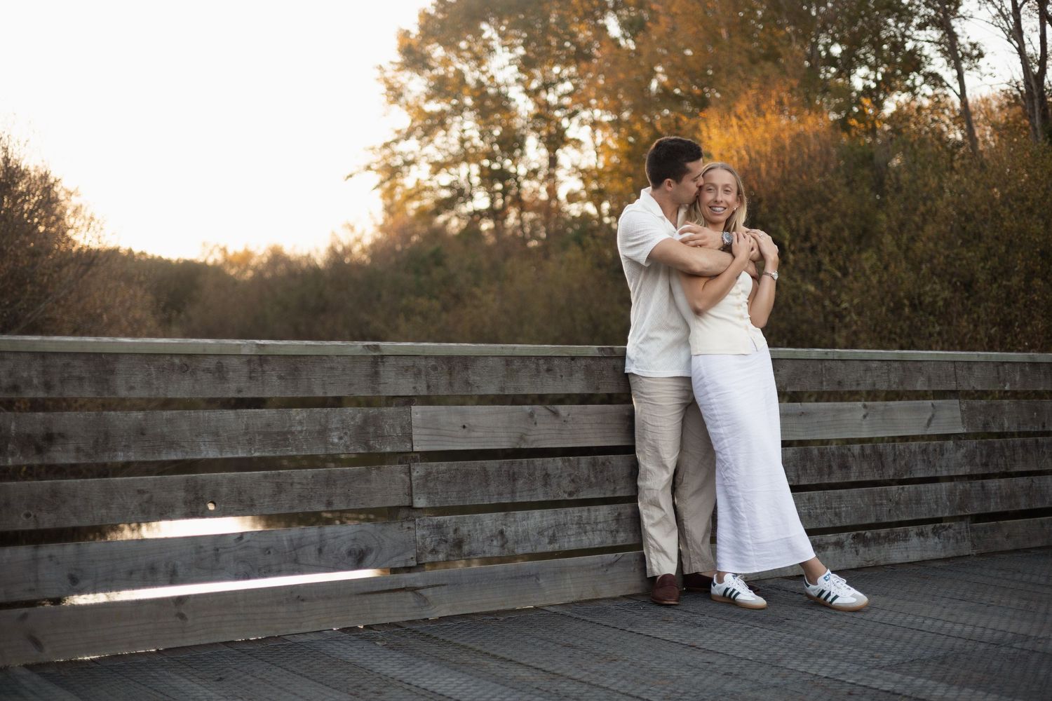 couple hugging on bridge during session at the groynes Christchurch