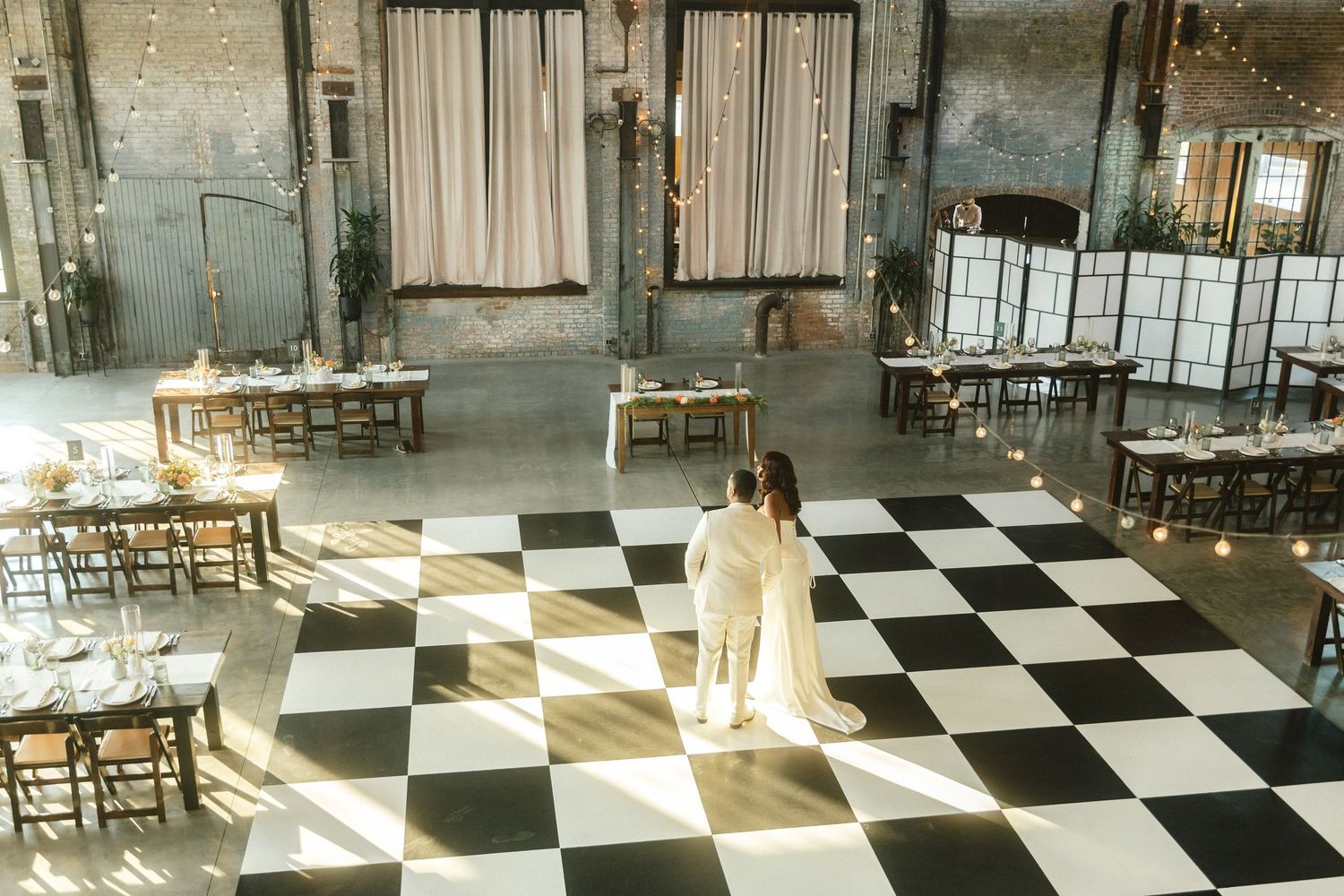 Sunlit indoor venue with black and white checkered floor and elegant window light.