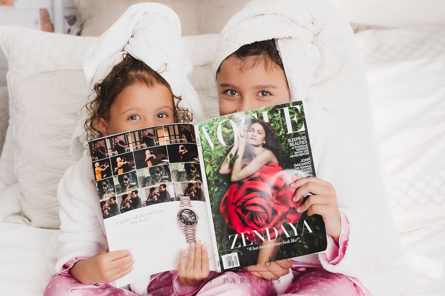 Two people in white bedding reading magazines together while relaxing in bed.