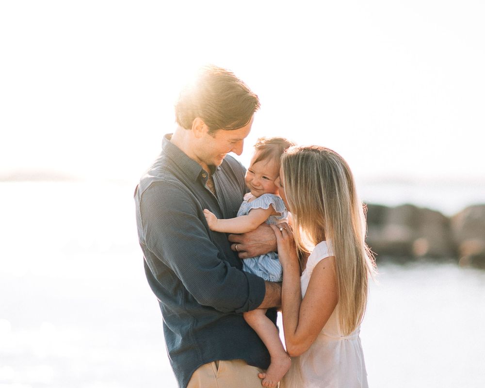 Romantic couple shares tender moments together by the waterfront at sunset in a series of intimate photographs.