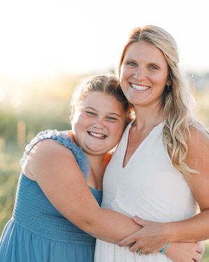 A pair in matching blue and white outfits share joyful embraces during an outdoor photoshoot.