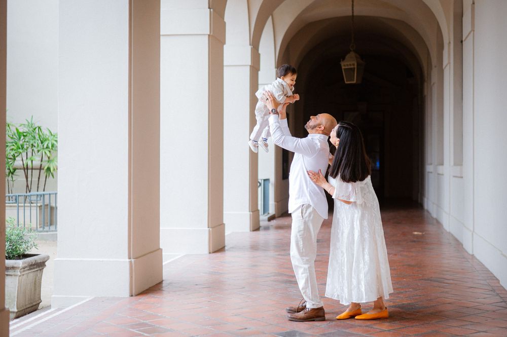 Family sharing joyful moment together in arched hallway.