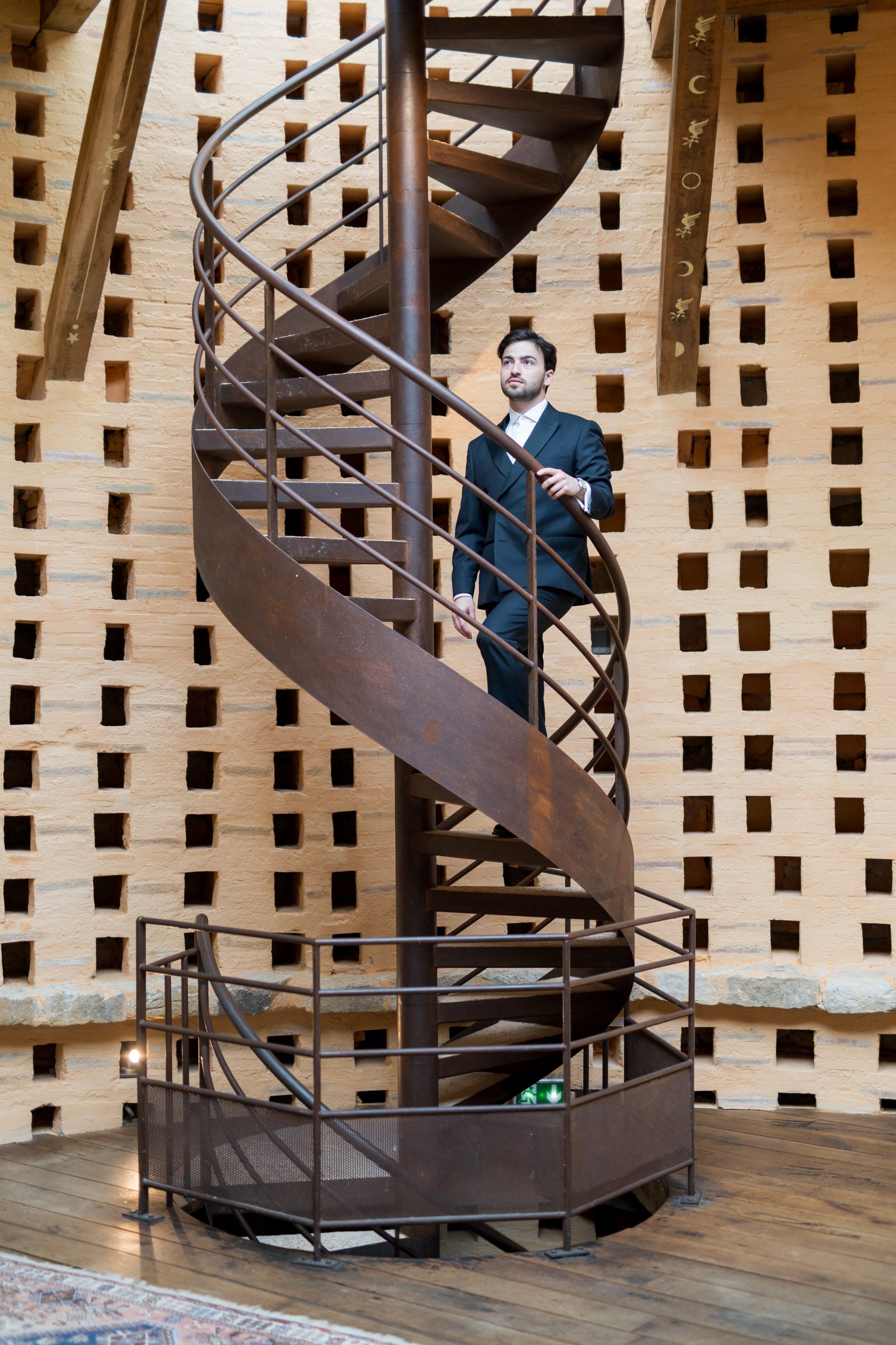 Couple descendant un escalier en colimaçon dans un décor contemporain, scène graphique et moderne.
