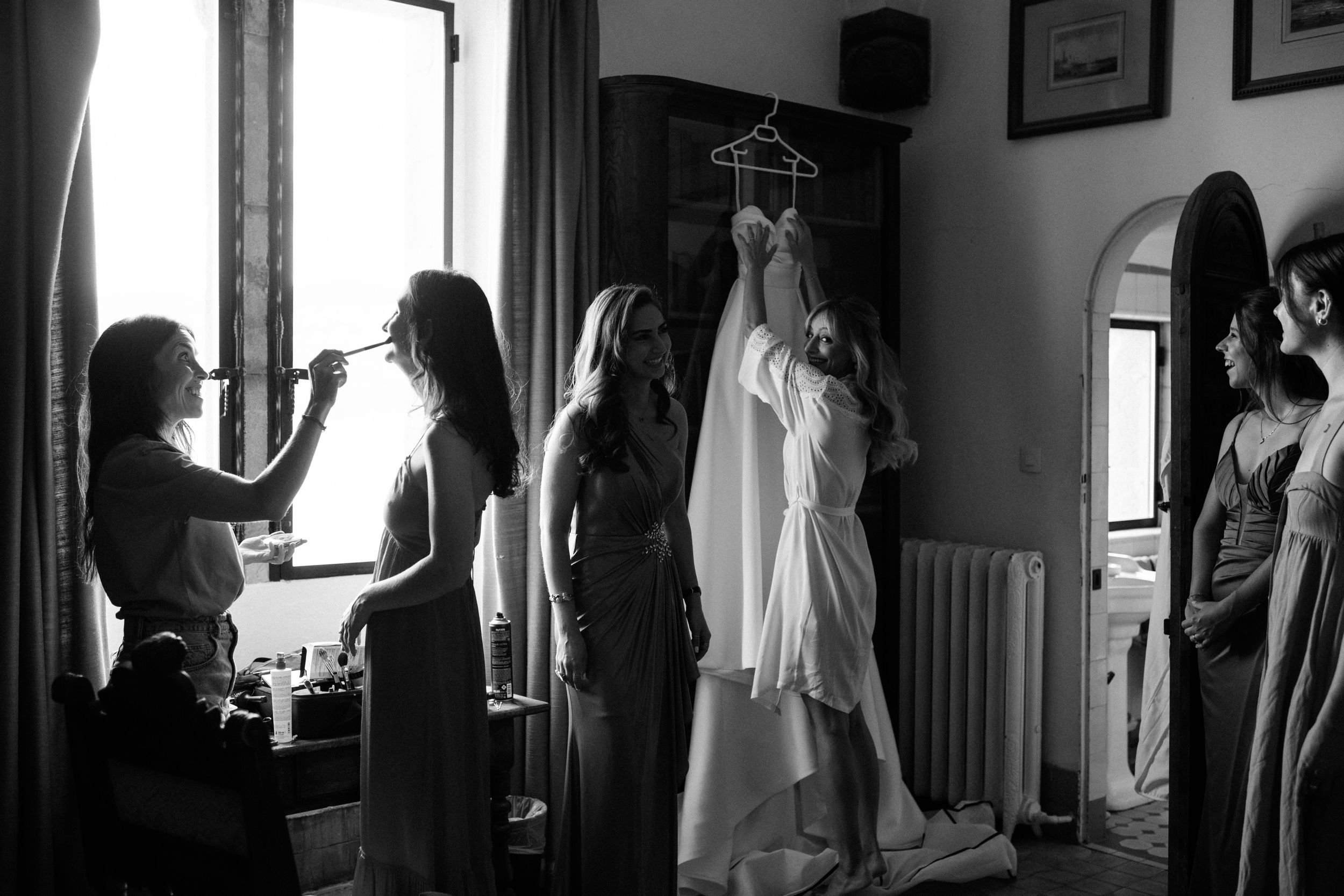 Mariée entourée de ses proches lors des préparatifs, scène en noir et blanc chargée de douceur.