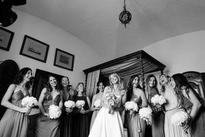Mariée entourée de ses demoiselles d’honneur en noir et blanc, ambiance joyeuse et préparatifs de cérémonie.