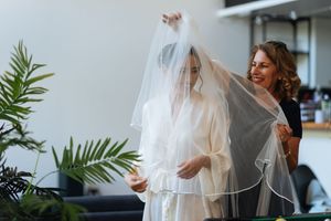 Pose du voile sur la mariée entourée de ses proches, moment tendre et lumineux avant la cérémonie.