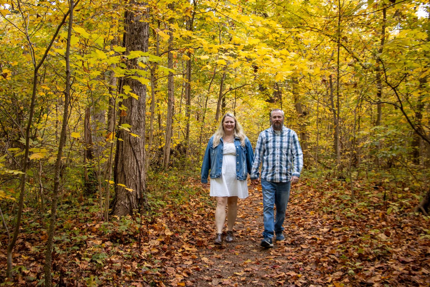 Cincinnati fall mini session at Sharon Woods Park featuring a happy family walking together outdoors beneath colorful trees and autumn