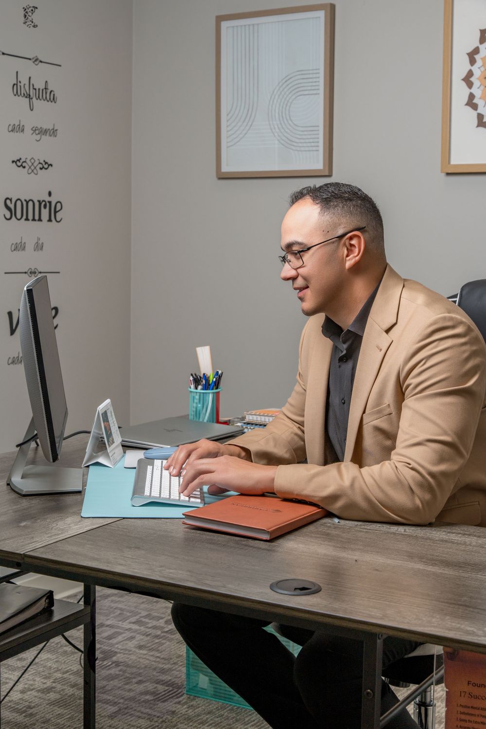 Business professional working at computer desk in modern office setting.