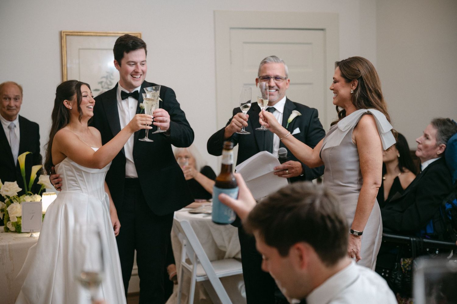 Bride and groom clinking their glasses during wedding toasts.