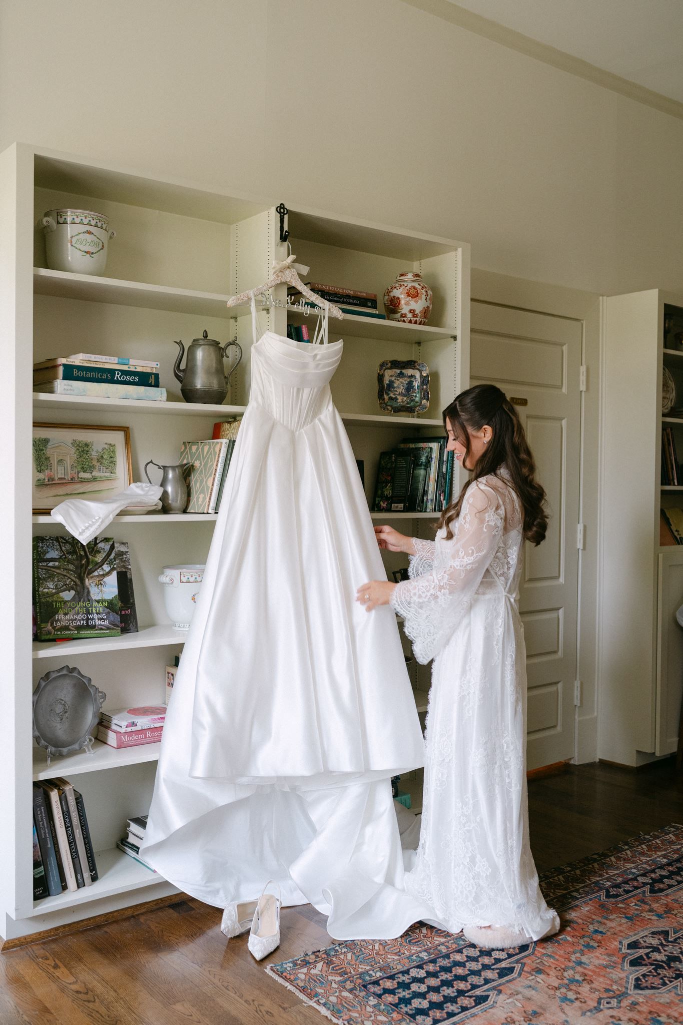 Emma admiring her wedding dress hanging on a bookcase at the River Oaks garden Club.