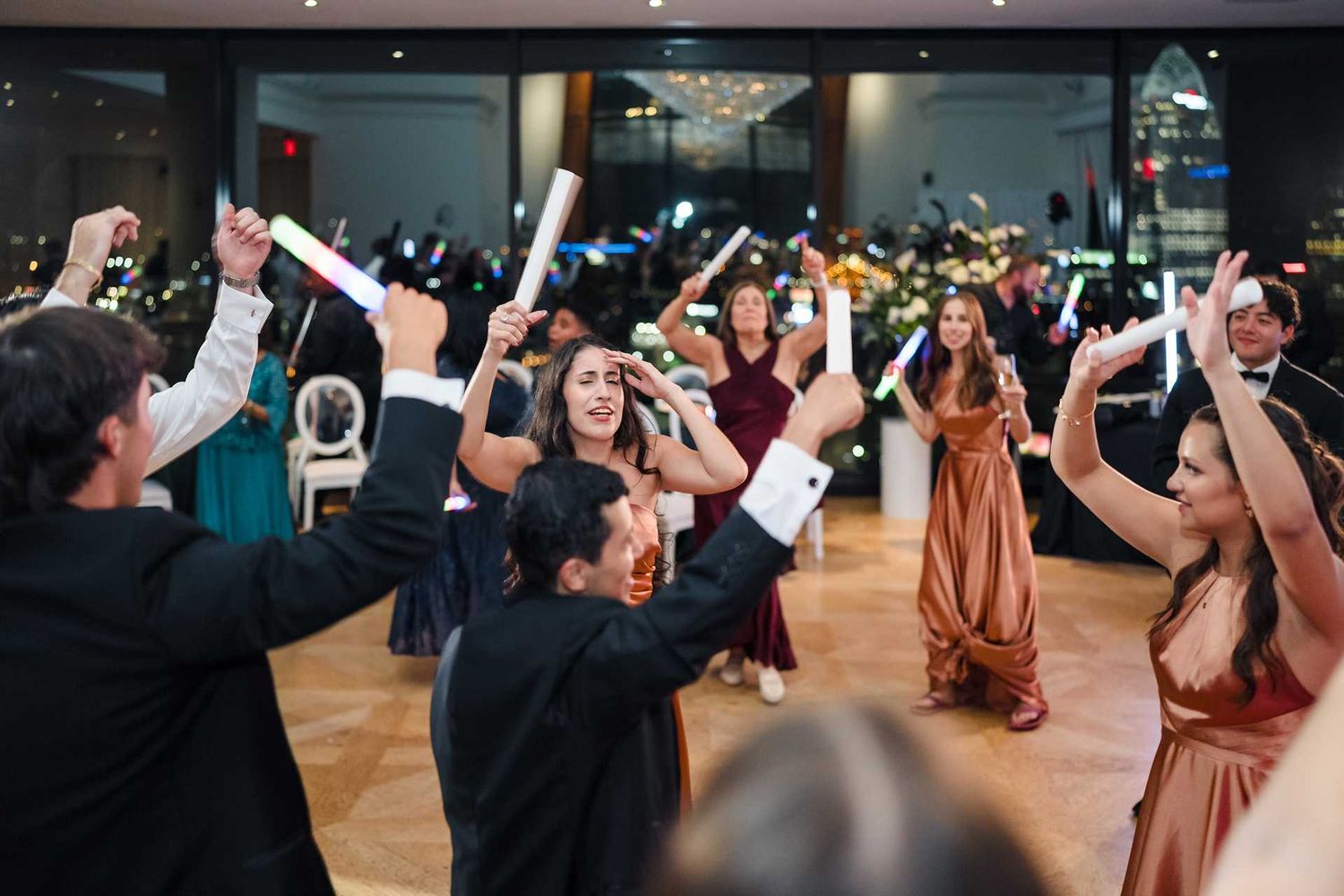 wedding Guests dancing and waving glow sticks at the view wedding