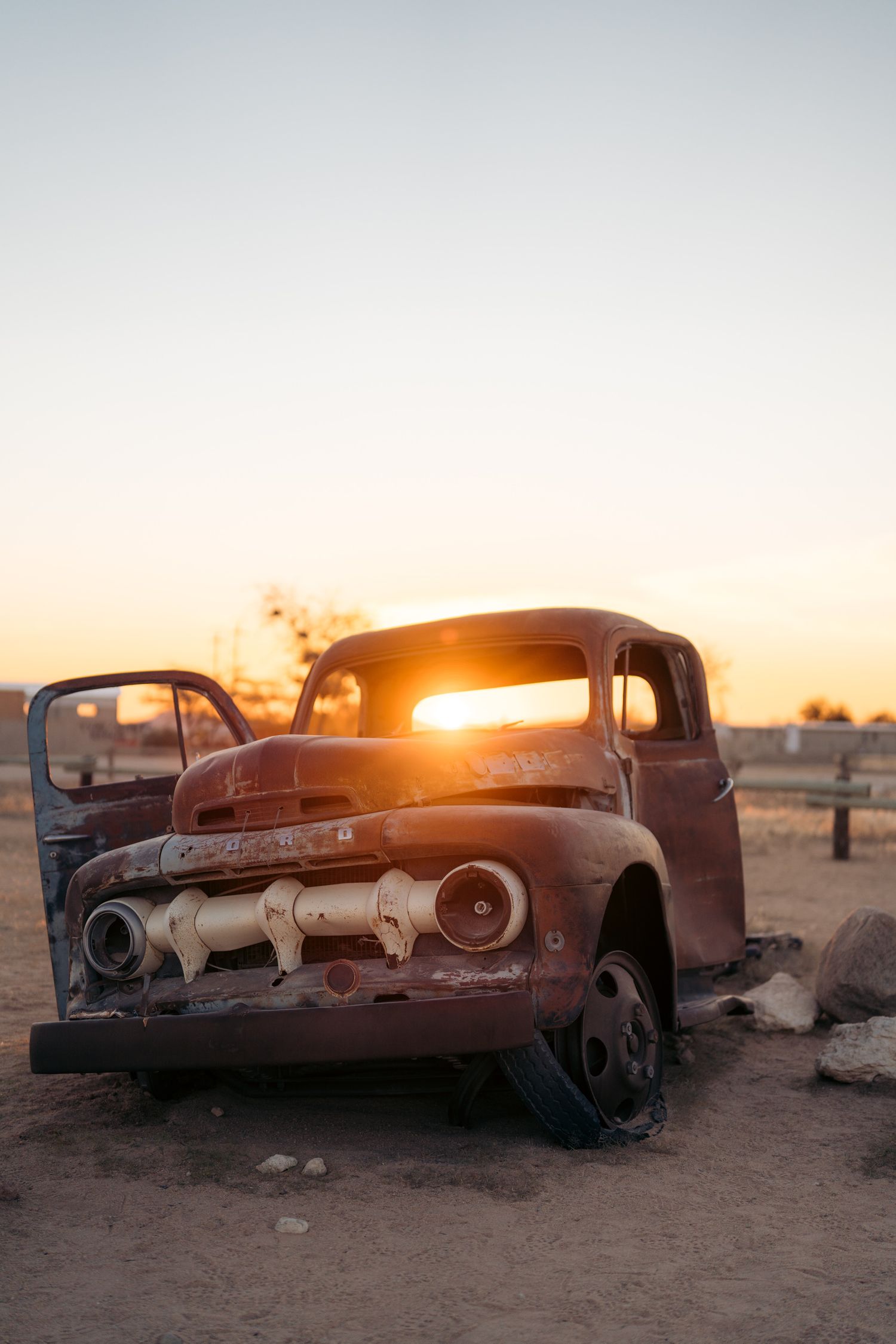 coucher du soleil à traver les pare-brise d'une vieille voiture dans le désert namibien à solitaire