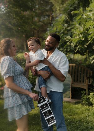 A heartwarming pregnancy announcement photo series showing a couple embracing and holding ultrasound images in a garden setting.