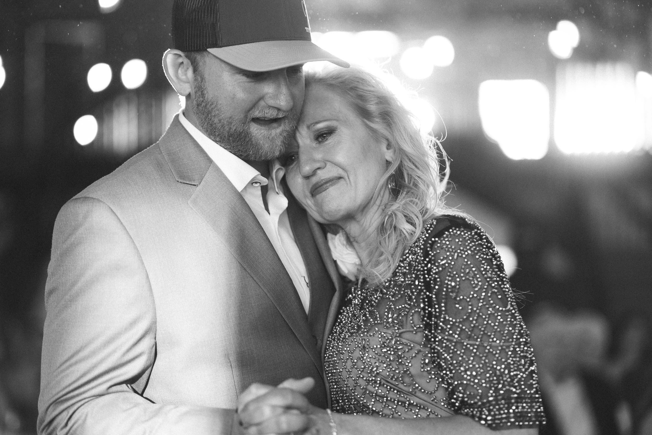Black and white photo of a couple sharing a tender dance embrace at a formal event.