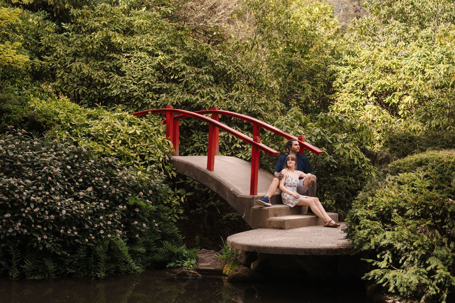 Grant and Madisyn sitting at the Kubota Gardens Seattle after their surprise proposal in Seattle