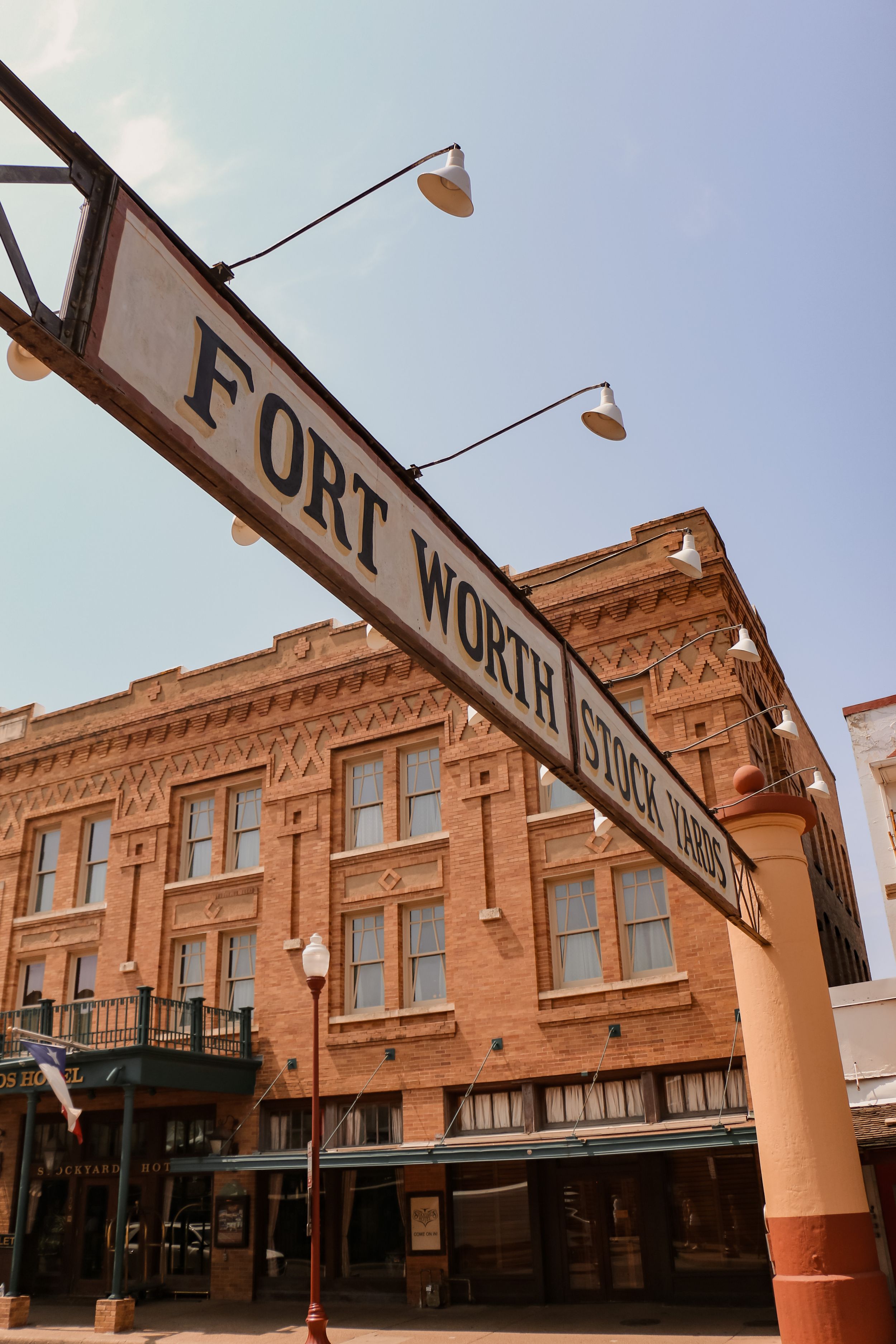 Historic Fort Worth brick building with vintage street sign and period lighting fixtures.