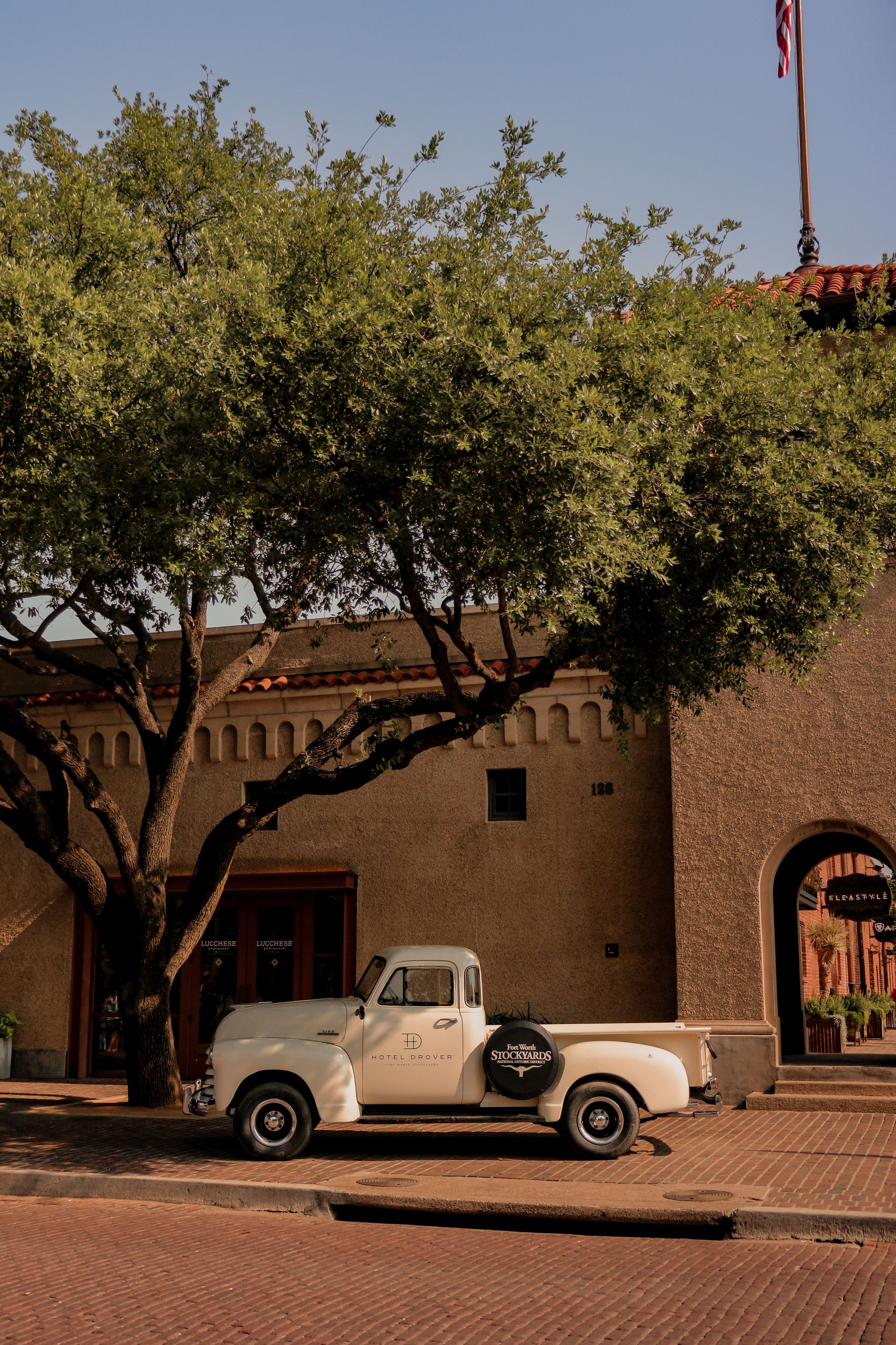 A vintage pickup truck parked outside a southwestern style adobe building.