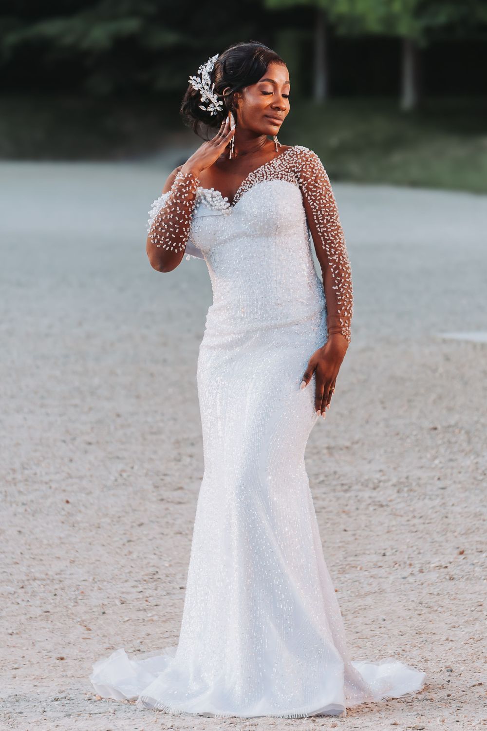 Mariée posant seule dans le parc et mettant sa robe en valeur