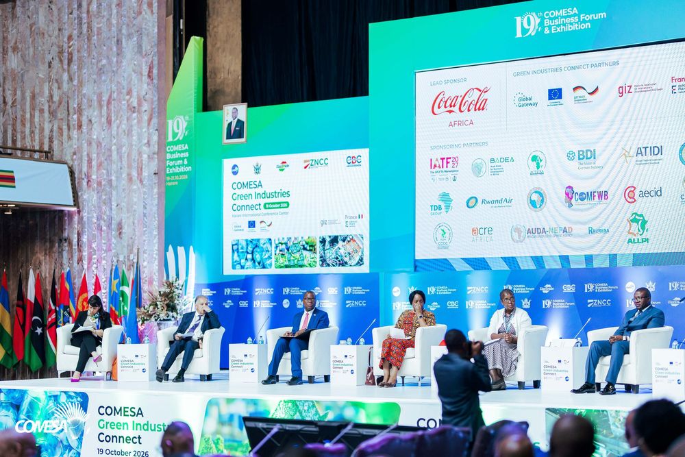Panelists seated on stage at the COMESA Green Industry Connect conference, with sponsor logos including Coca-Cola on a large backdrop.