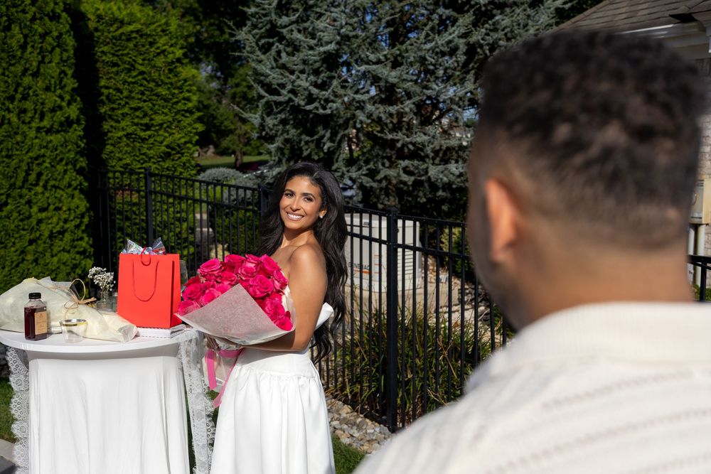 Woman holding red roses after a surprise proposal at an outdoor garden in New Jersey