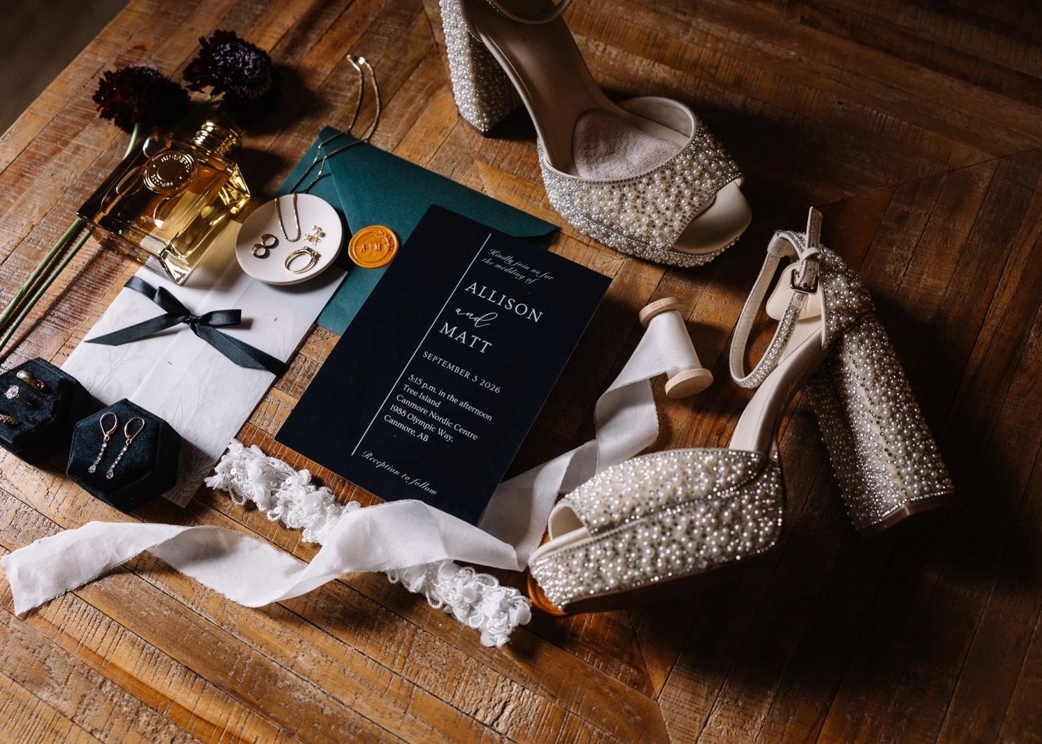 Allison and Matt wedding details: navy invitation for Canmore Nordic Centre, pearl platform heels, wax seal and earrings
