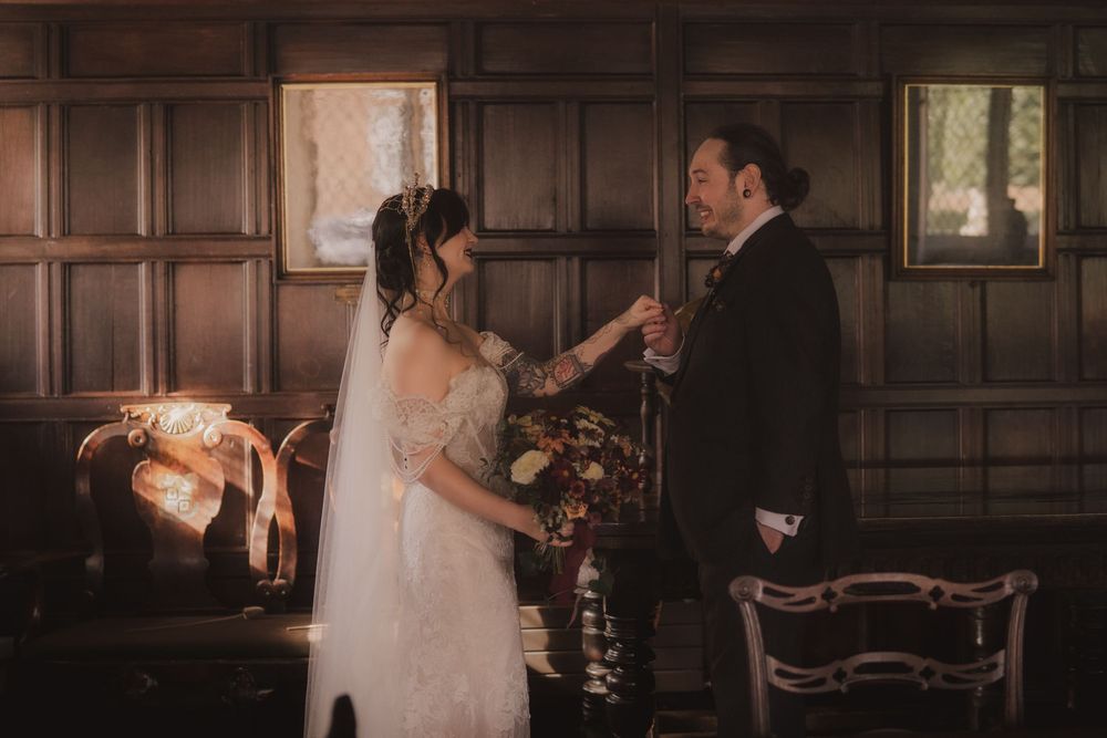 Bride and groom sharing a tender moment in an elegant wood-paneled room during their wedding ceremony.