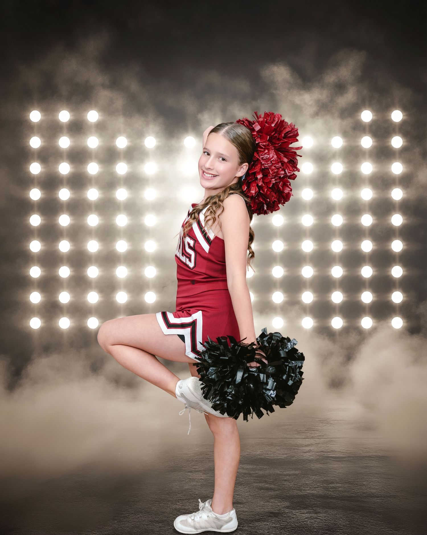 A cheerleader poses on a football field with pom-poms, a red megaphone, and white 2027 letters.