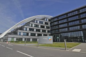 Photographie d’architecture contemporaine montrant un immeuble aux façades vitrées et aux lignes courbes.