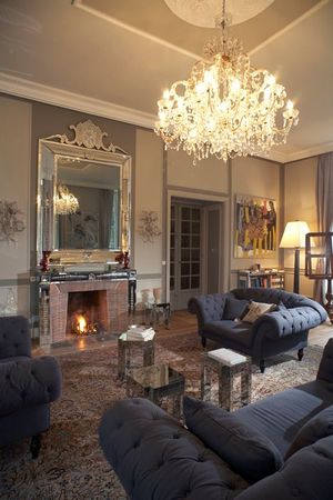 Salon élégant avec cheminée, lustre en cristal, mobilier classique et décoration intérieure raffinée.