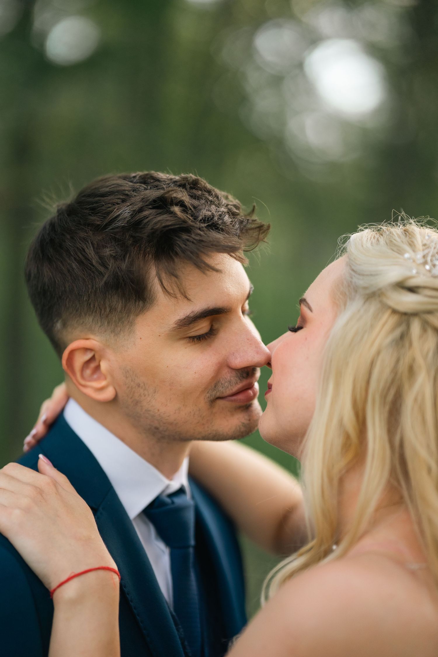 Egy romantikus esküvői pillanat egy pár között meghitt közeli felvételen, lágy bokeh háttérrel.