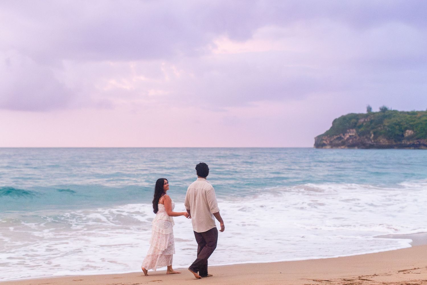 Engagement portrait on the beach. Man and woman walking along water's edge. Playa Guajataca, Isabela, Puerto Rico.
