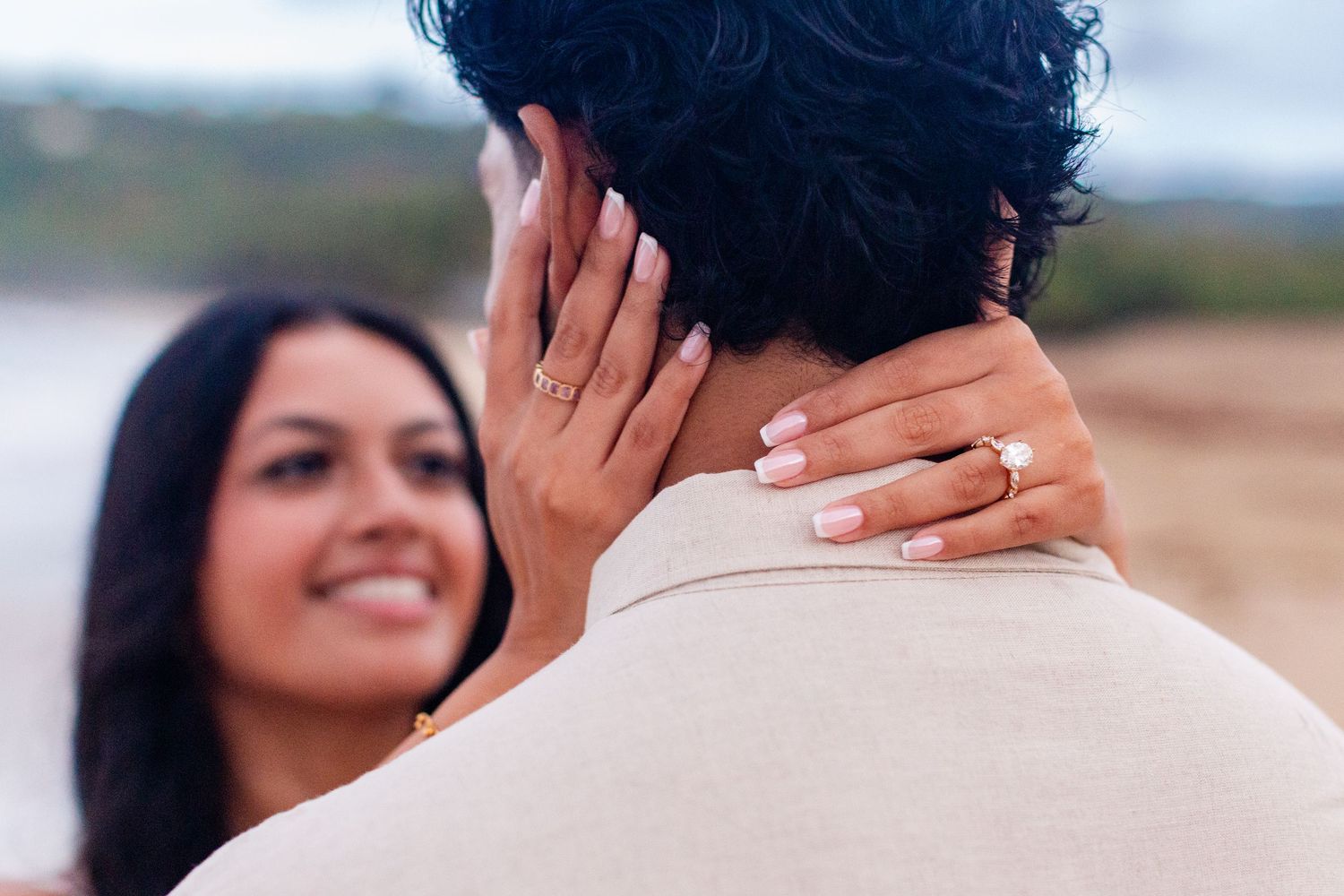 Engagement portrait on the beach. Focus on woman's hand with her ring. Playa Guajataca, Isabela, Puerto Rico.