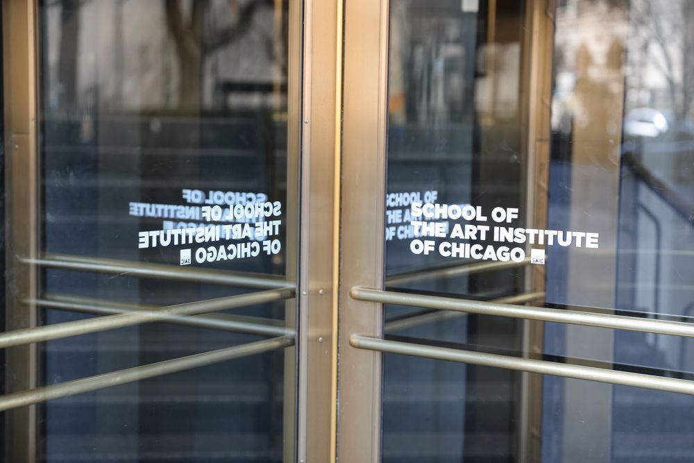 Glass doors of the School of the Art Institute of Chicago building entrance with gold frames.