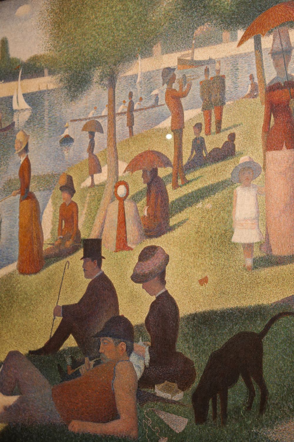 Georges Seurat pointillist painting Sunday on La Grande Jatte with figures relaxing by the Seine river in Paris.