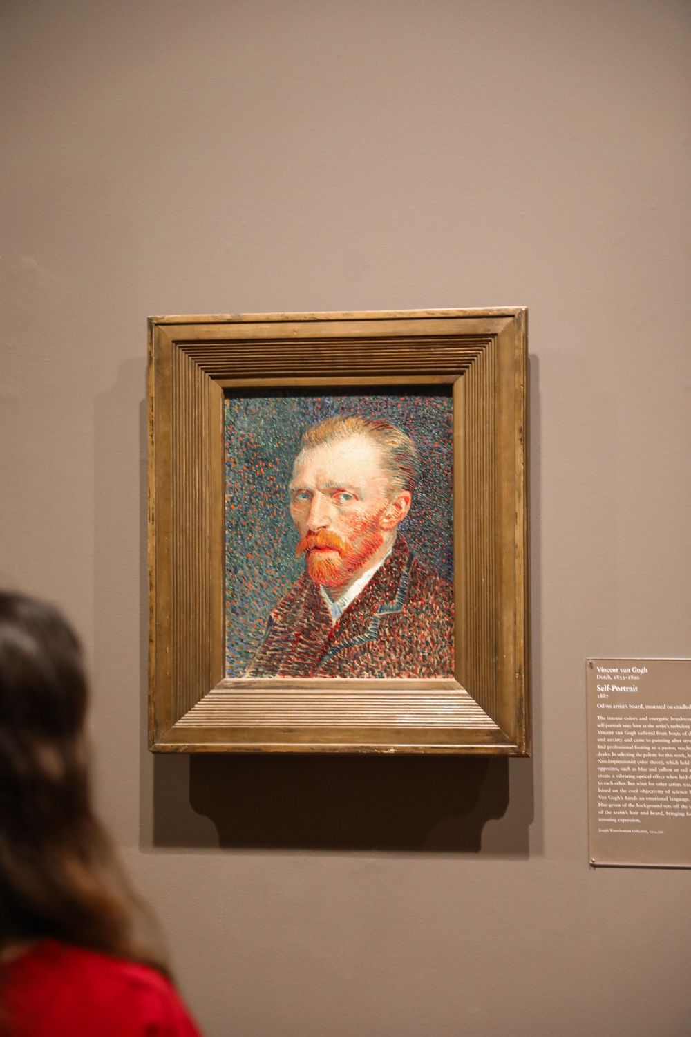 Vincent van Gogh Self Portrait painting displayed in a wooden frame at a museum gallery.