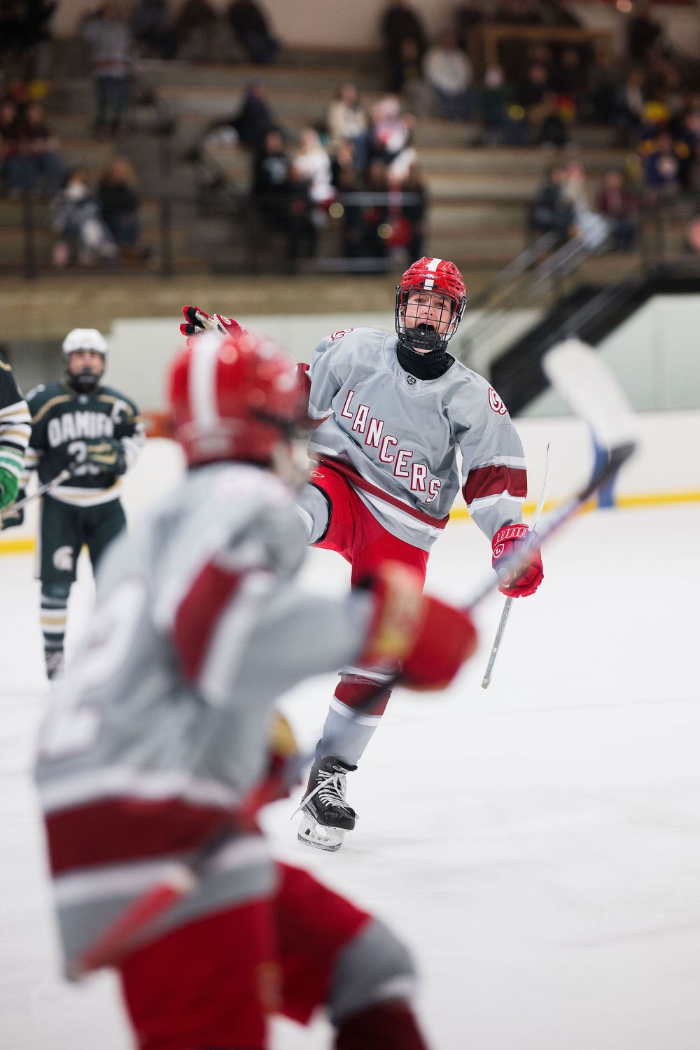 Orange Lutheran High School ice hockey athletes celebrate after goal